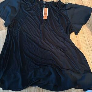Black nylon with black chiffon sleeves and trim around the bottom of blouse.